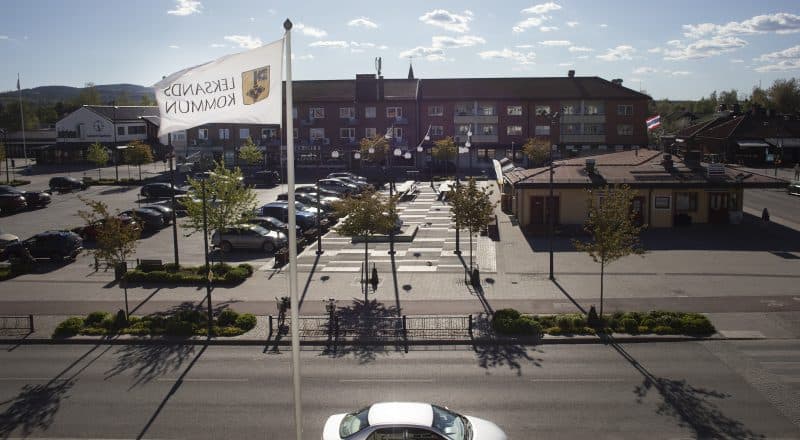 En Leksandsflagga vajar mellan kommunhuset och parkeringen i centrala Leksand.