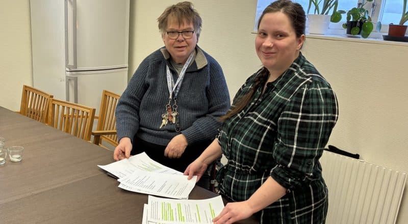 Stefan Hällberg och Linda Enmalm ser nöjda ut vid ett bord med papper på.