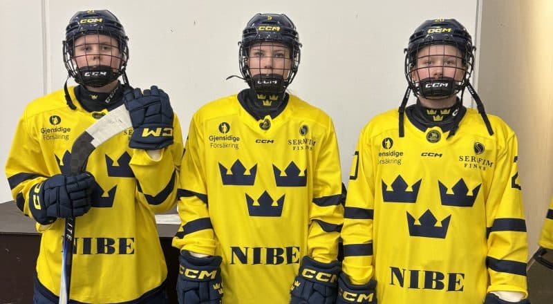 Tre spelare i matchställ med tre kronor på.