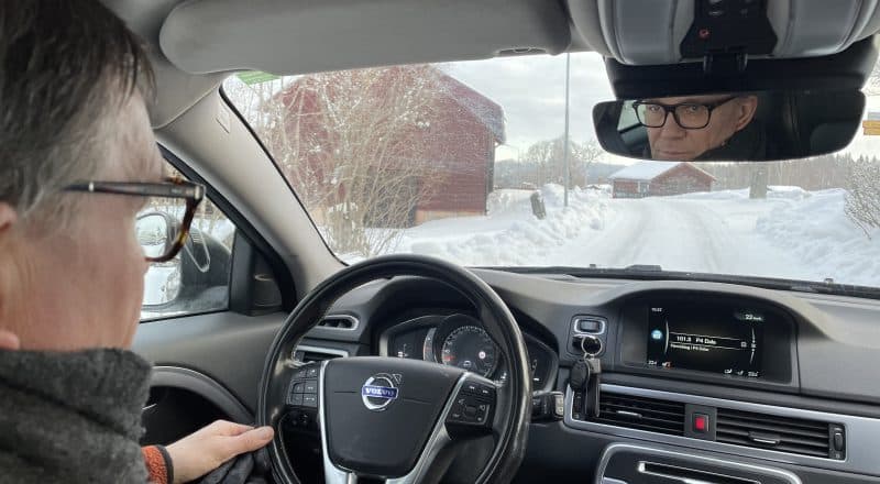 Per-Anders Winge bakom ratten på en bil, tittar in i backspegeln.