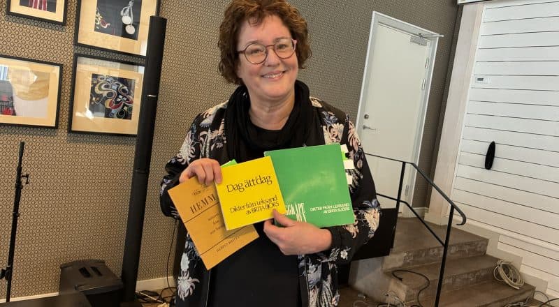 Birgitta Back Laszlo ler mot kameran med tre böcker i handen.