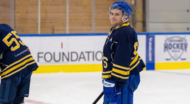 Markus Karlsson Åberg står på isen i sitt matchställ och tittar in i kameran.