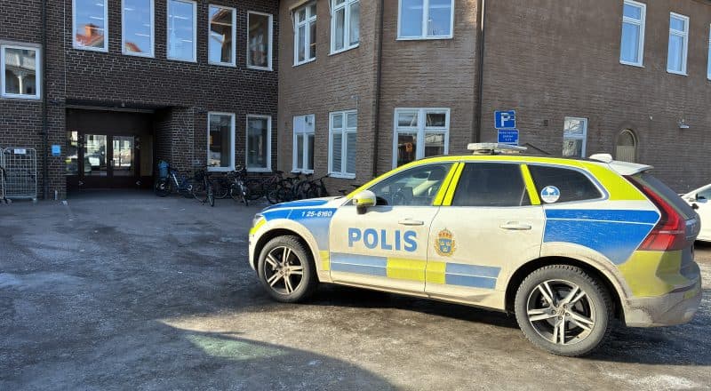 Polisbil framför skolentrén.