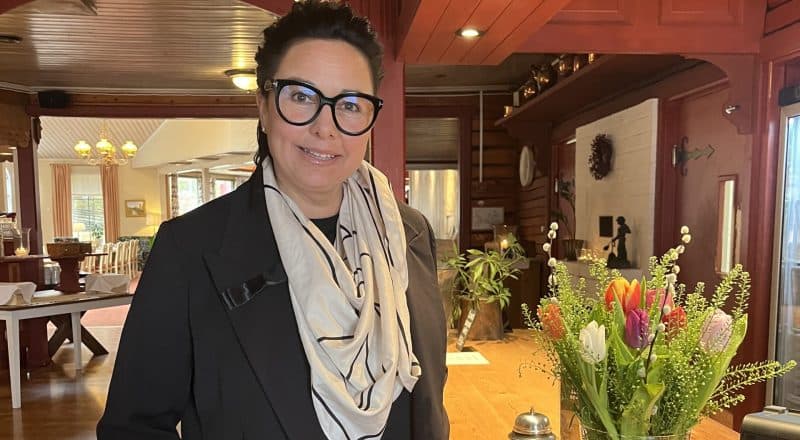 Emmalina Backhans står vid Moskogens reception med en blombukett intill.