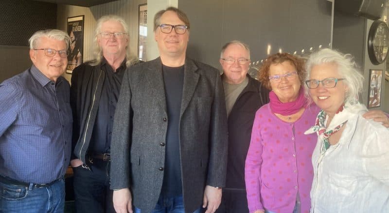 Sex glada personer uppställda på bild med Fredrik Winberg i mitten.