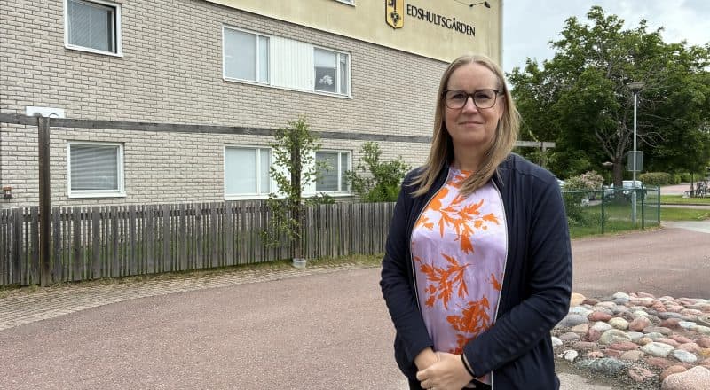 Kvinna står framför husvägg med texten Edshultsgården.
