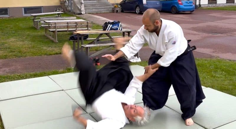 Mats Ahlin slänger Joaquin Muñoz ned i mjuka mattor som ligger utspridda på en gräsmatta.