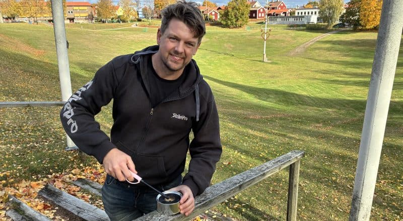 Jon Persson står vid trappan ned till Gropen i Leksand och håller en tändare mot en marschall.